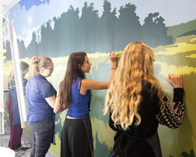 HRA art students work on a mural in the school's hydroponics laboratory
