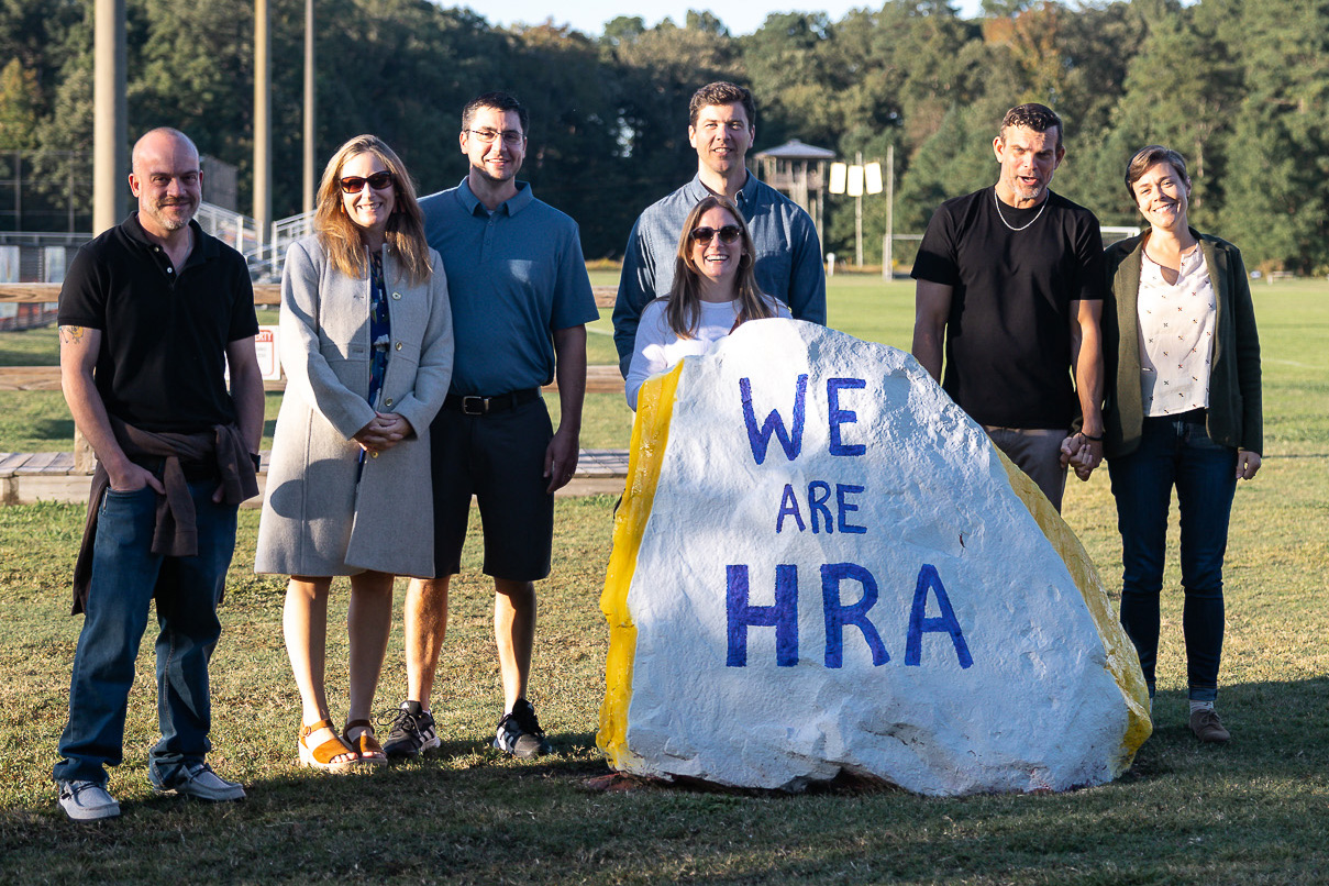 HRA alumni with "We Are HRA" rock
