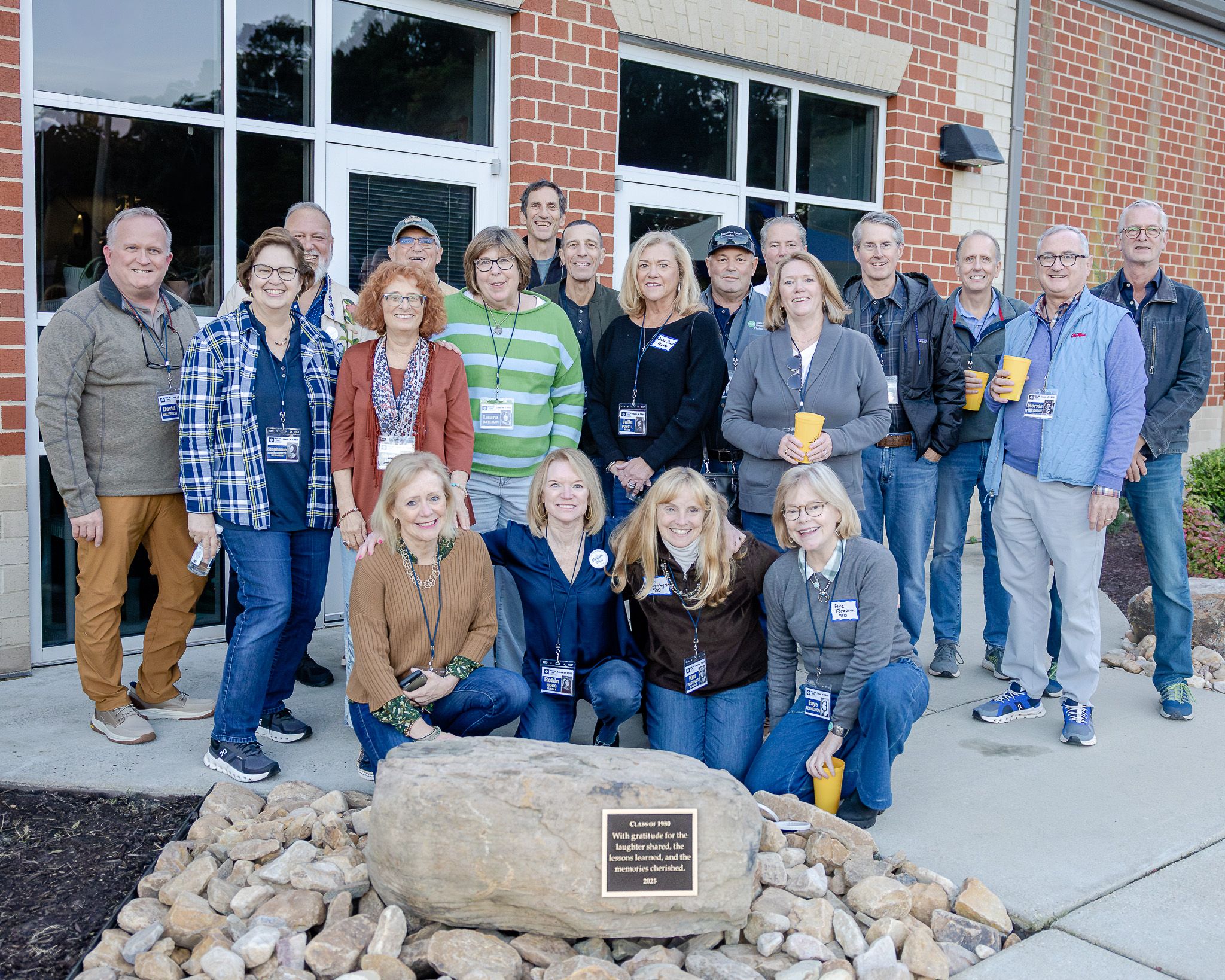 The HRA Class of 1980 poses with a commemorative boulder they gifted to the school