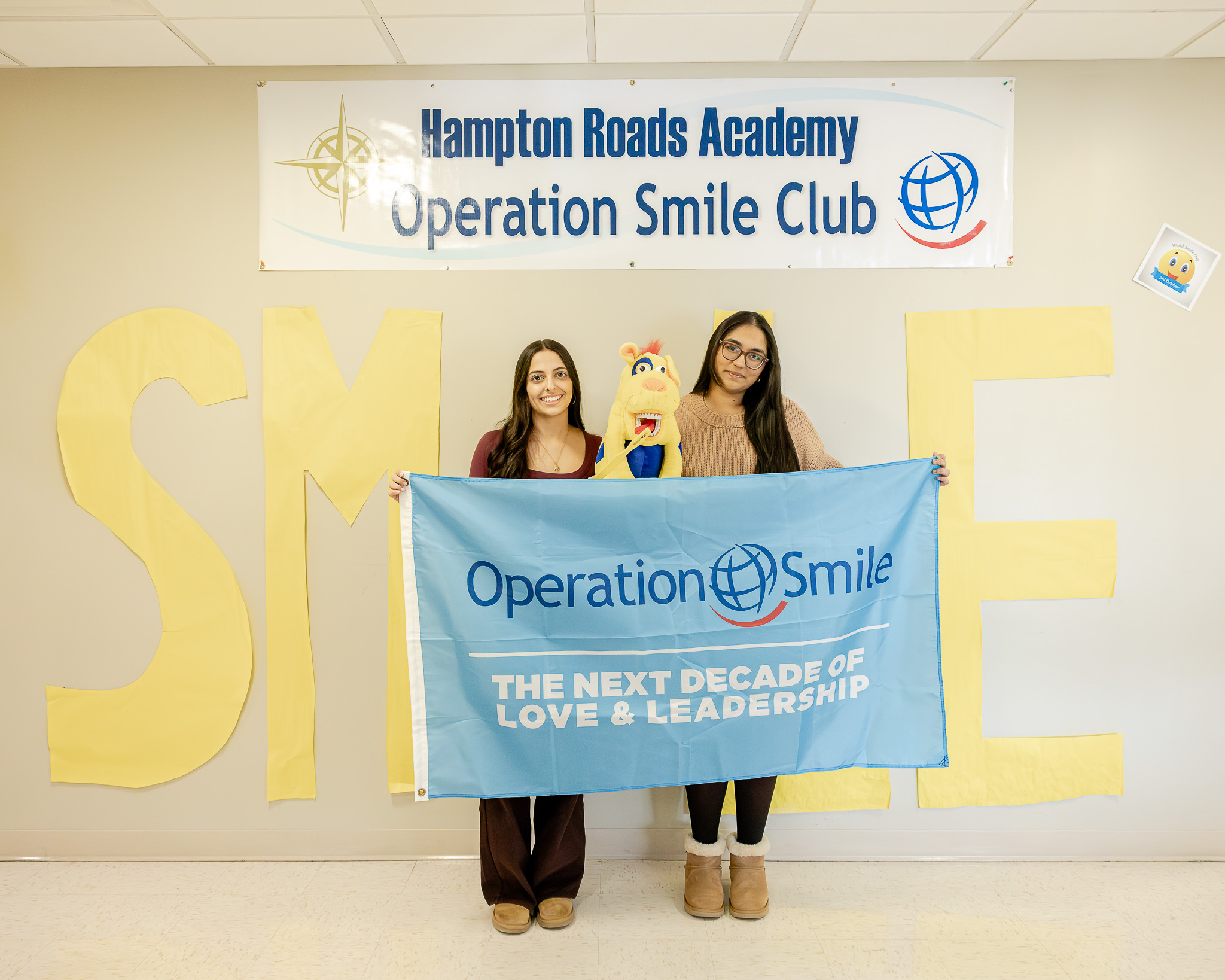HRA juniors Indira Hartke '27 and Gopi Patel '27 posing with an Operation Smile banner