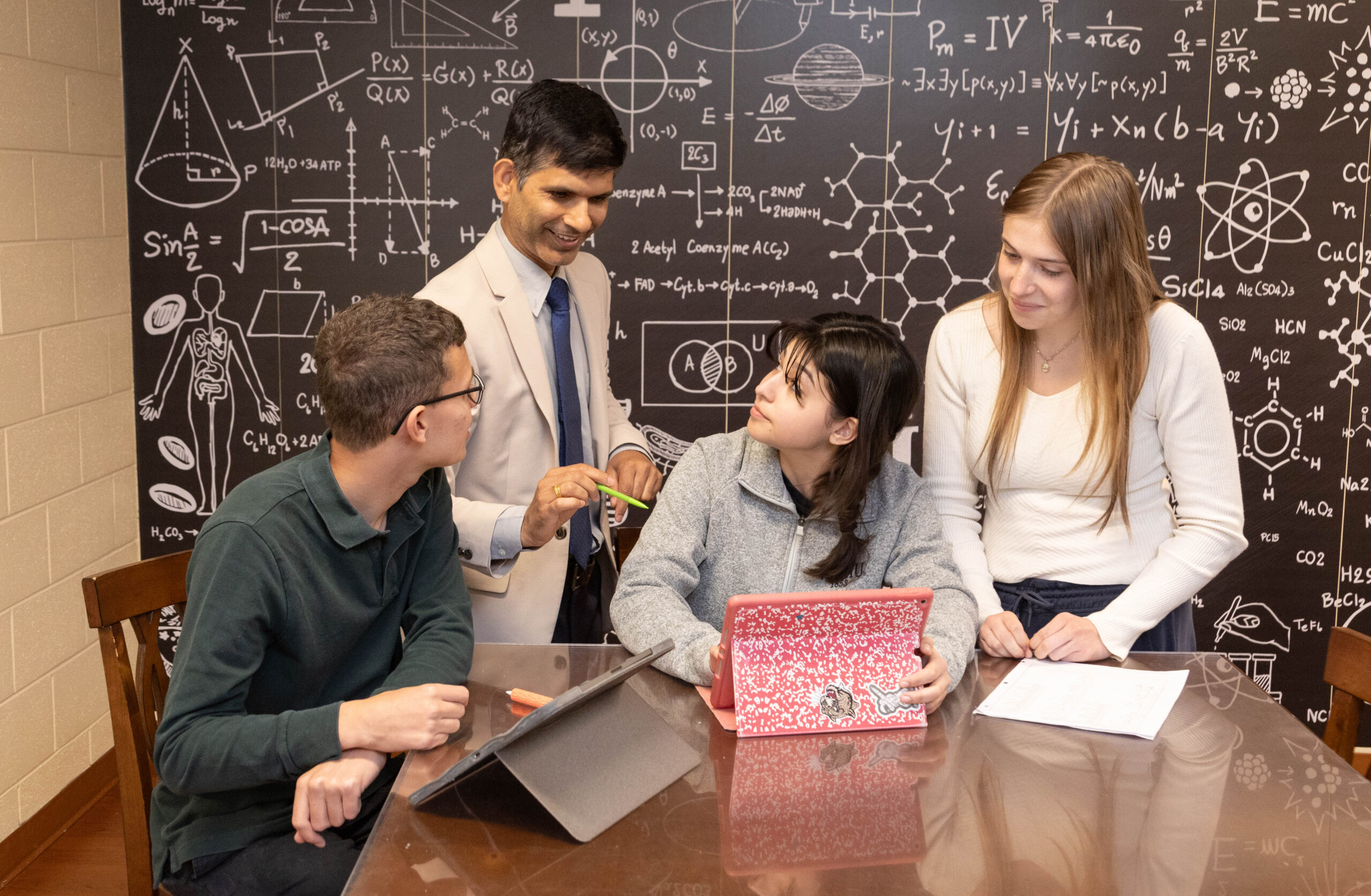 HRA Upper School physics teacher Devi Adhikari working with students