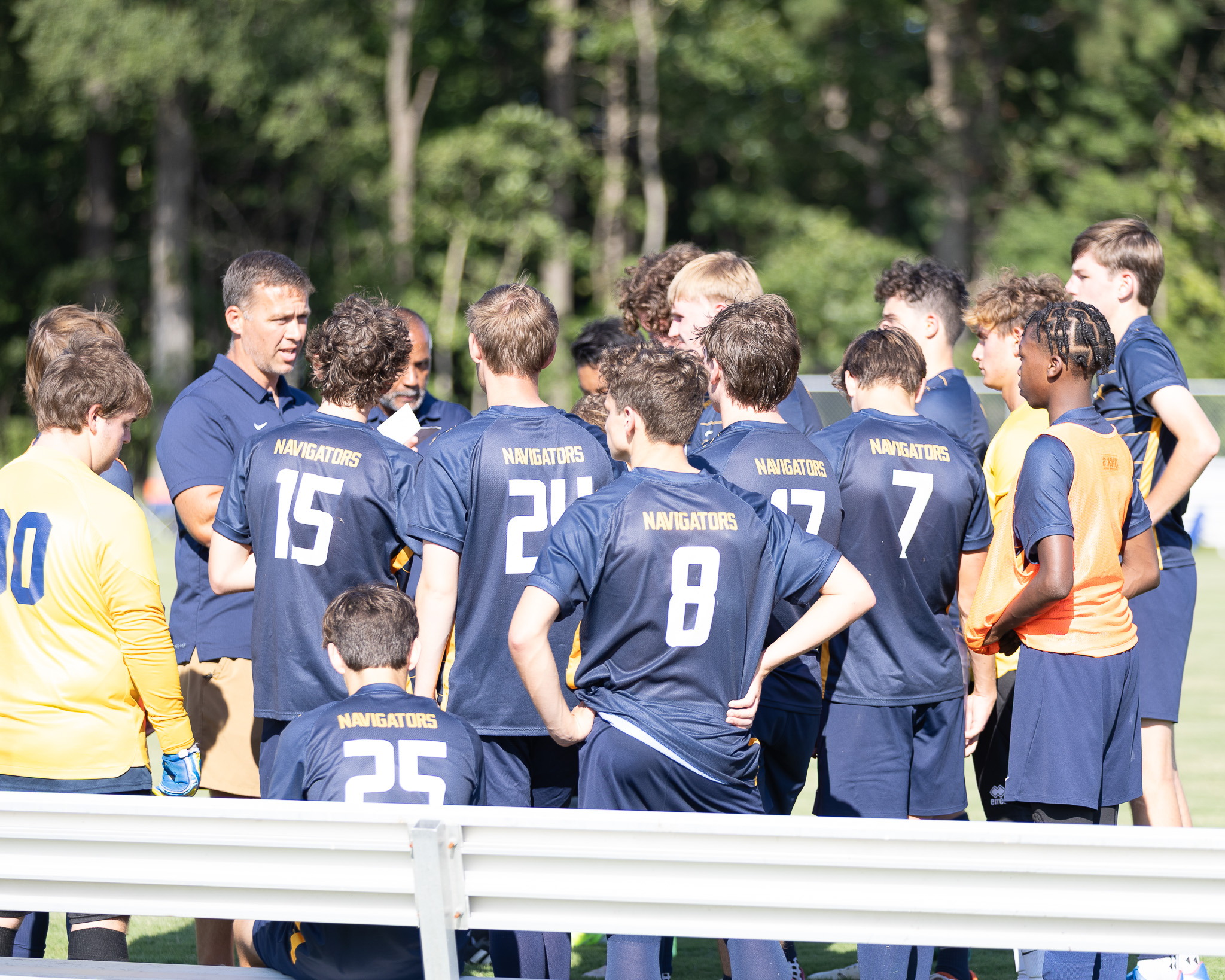 HRA Assistant Director of Athletics and varsity soccer coach Chris Mills huddling up with the varsity boys team