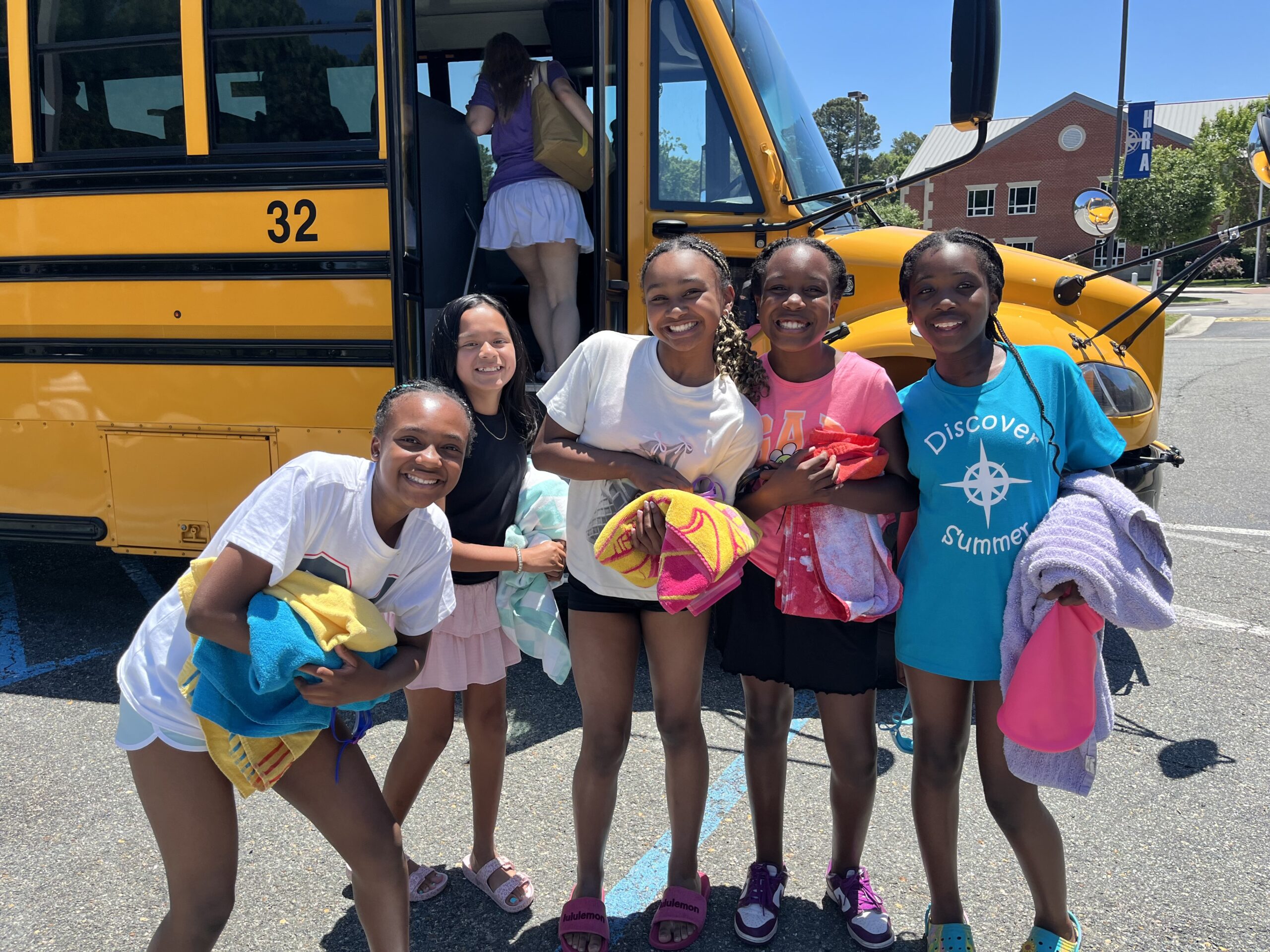 Smiling HRA campers in front of a bus