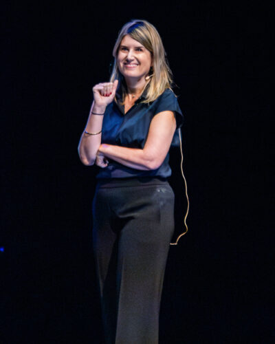 HRA alumna Emily Goodson '03 smiling on stage during an assembly in September 2026