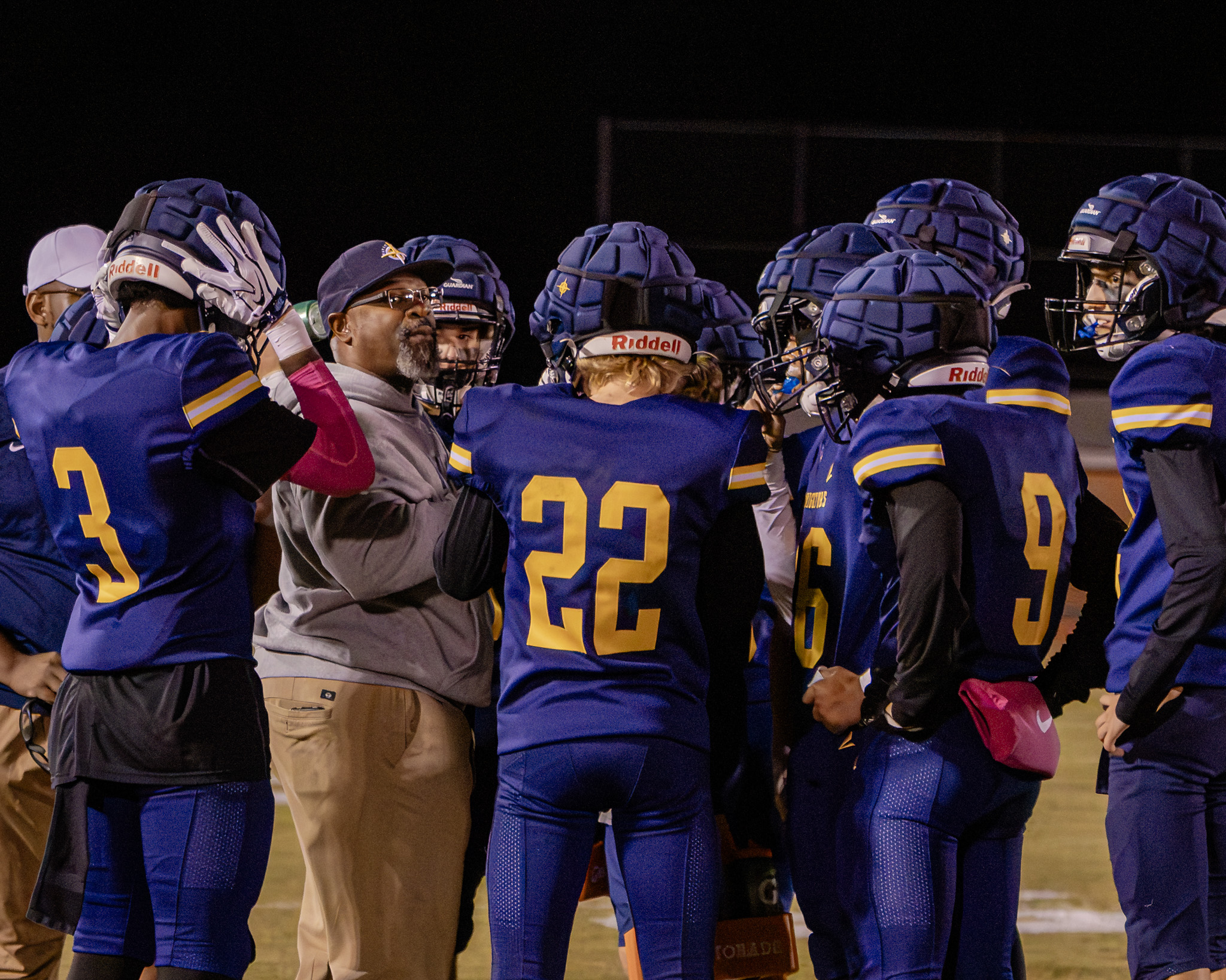 HRA varsity football coach Rodney Taylor in the huddle with his players