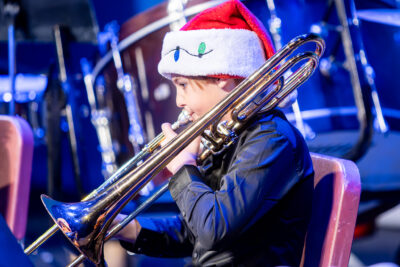 A member of the HRA concert band playing the trombone in a Santa cap