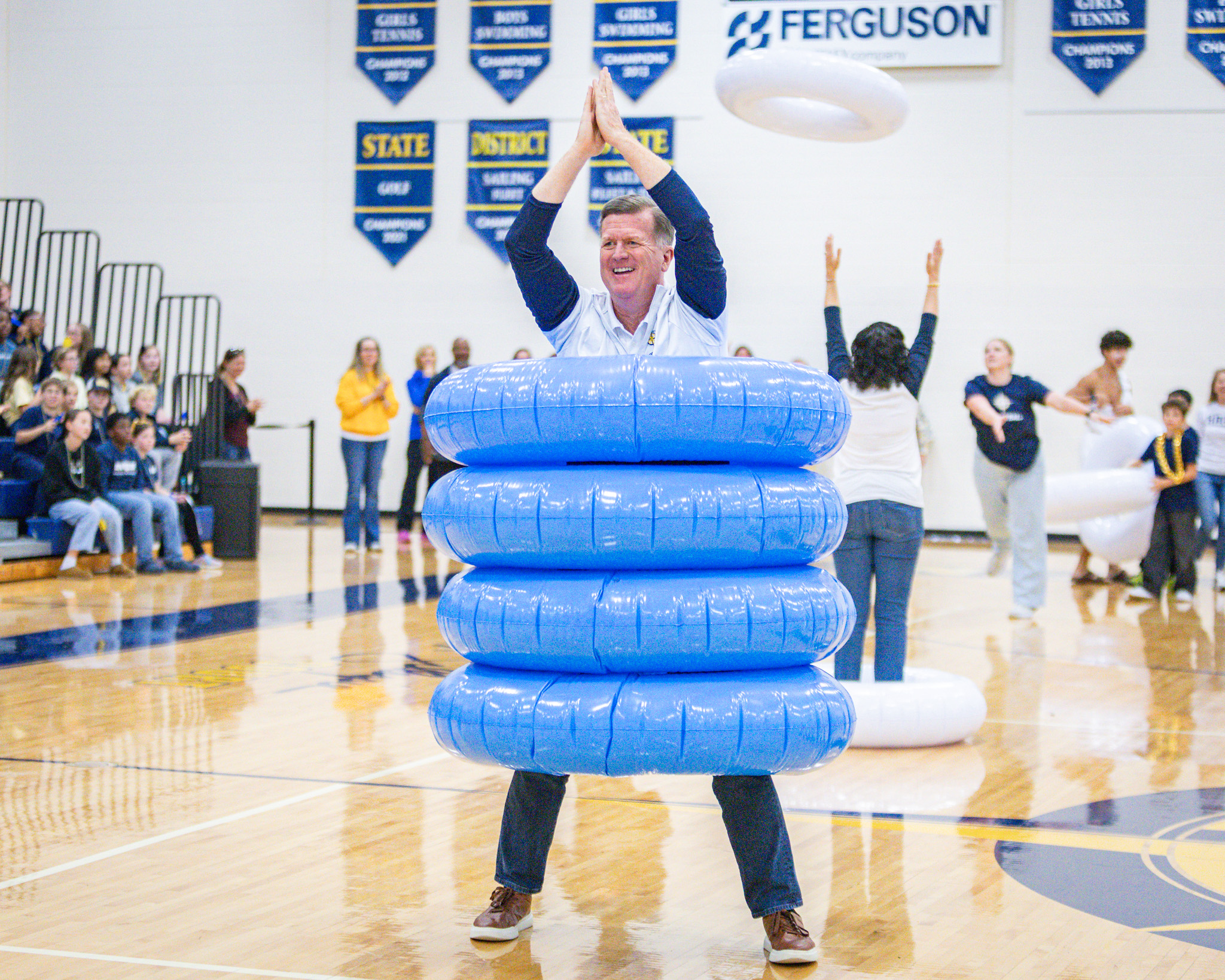 HRA Director of Admissions Ed Swanson surrounded by inflatable rings during a game at the 2026 Homecoming pep rally
